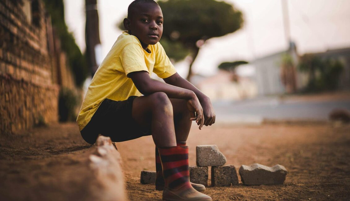 boy wearing yellow crew neck shirt and black short