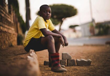 boy wearing yellow crew neck shirt and black short